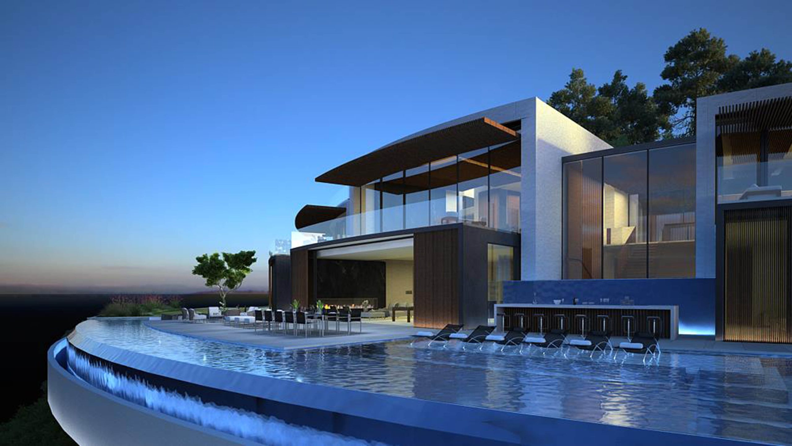 Bel Aire – Tione — Curved infinity pool with submerged lounge seating and glass pavilion at dusk