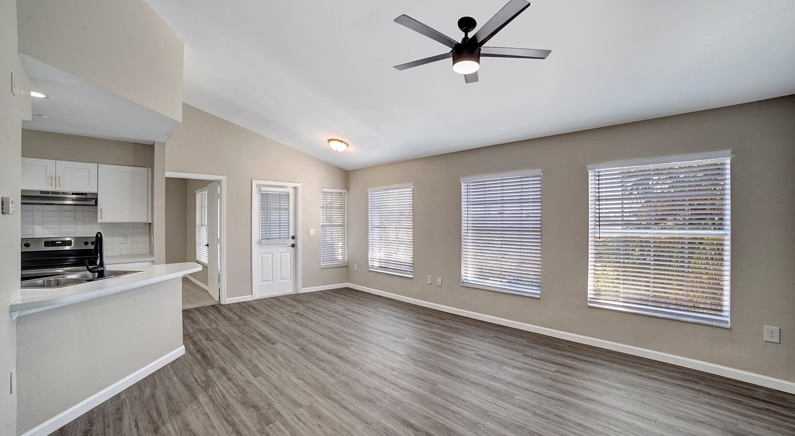 The Lennox — Open-plan living area with new LVP flooring, ceiling fan, and updated finishes